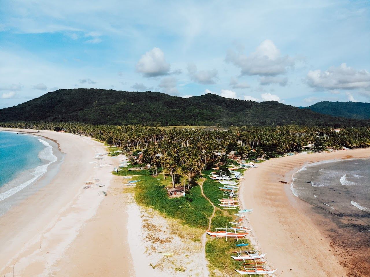 Golden sand and clear shallows at Nacpan Beach near El Nido in Palawan