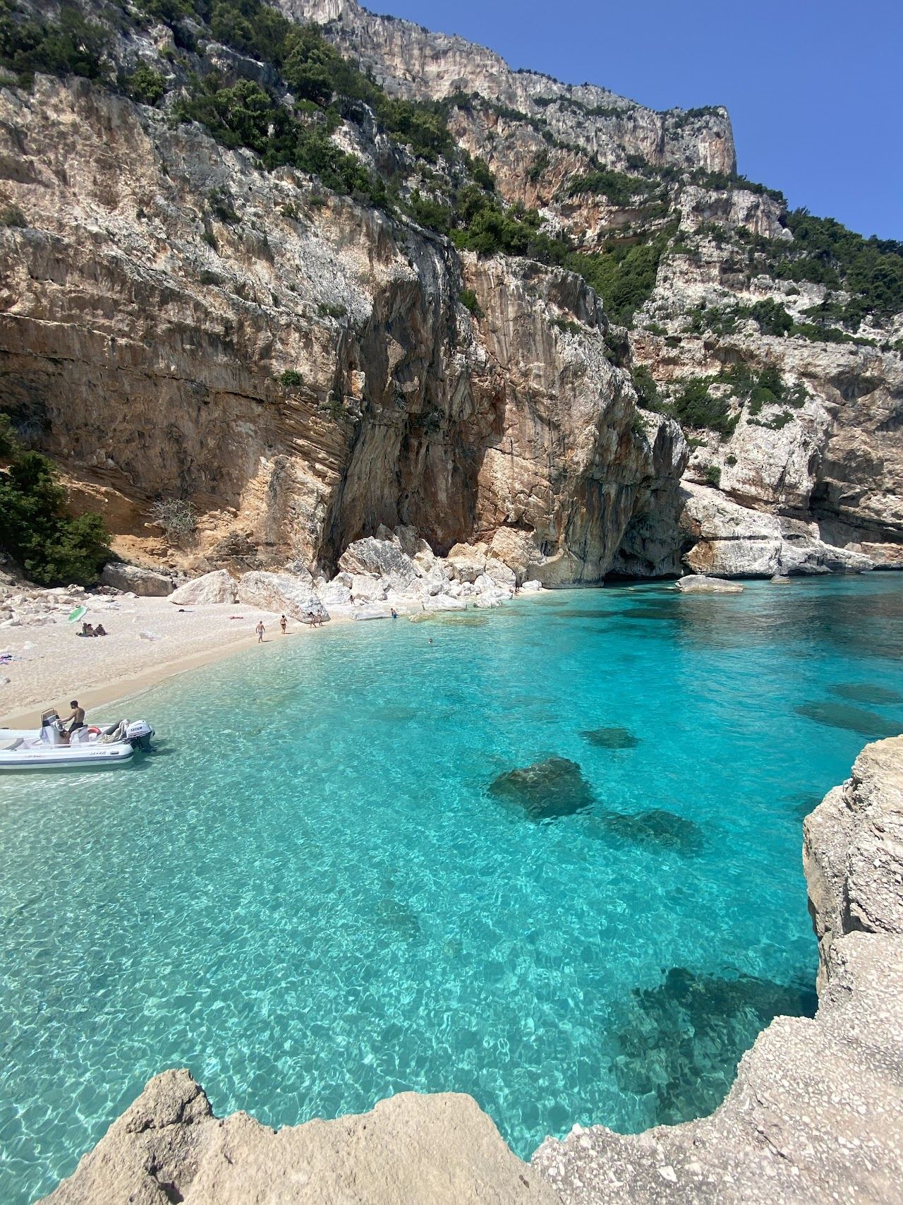 White pebbles and deep blue water at Cala Mariolu on the Gulf of Orosei