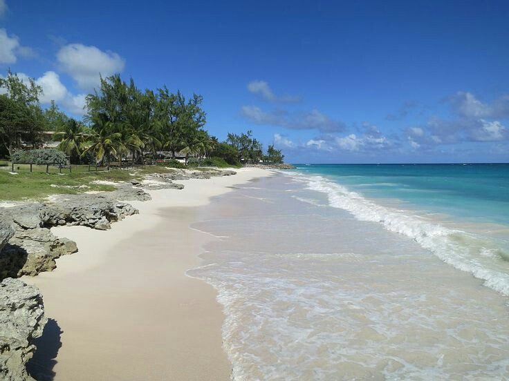 Wide white sand and breaking surf at Silver Sands beach on the south point of Barbados