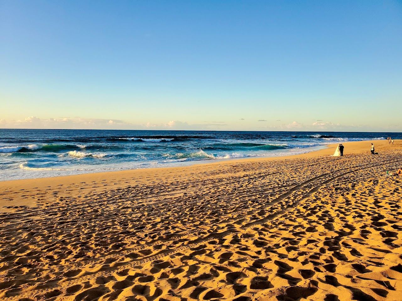Surfers and white spray at the Banzai Pipeline reef break off Ehukai Beach on Oahu