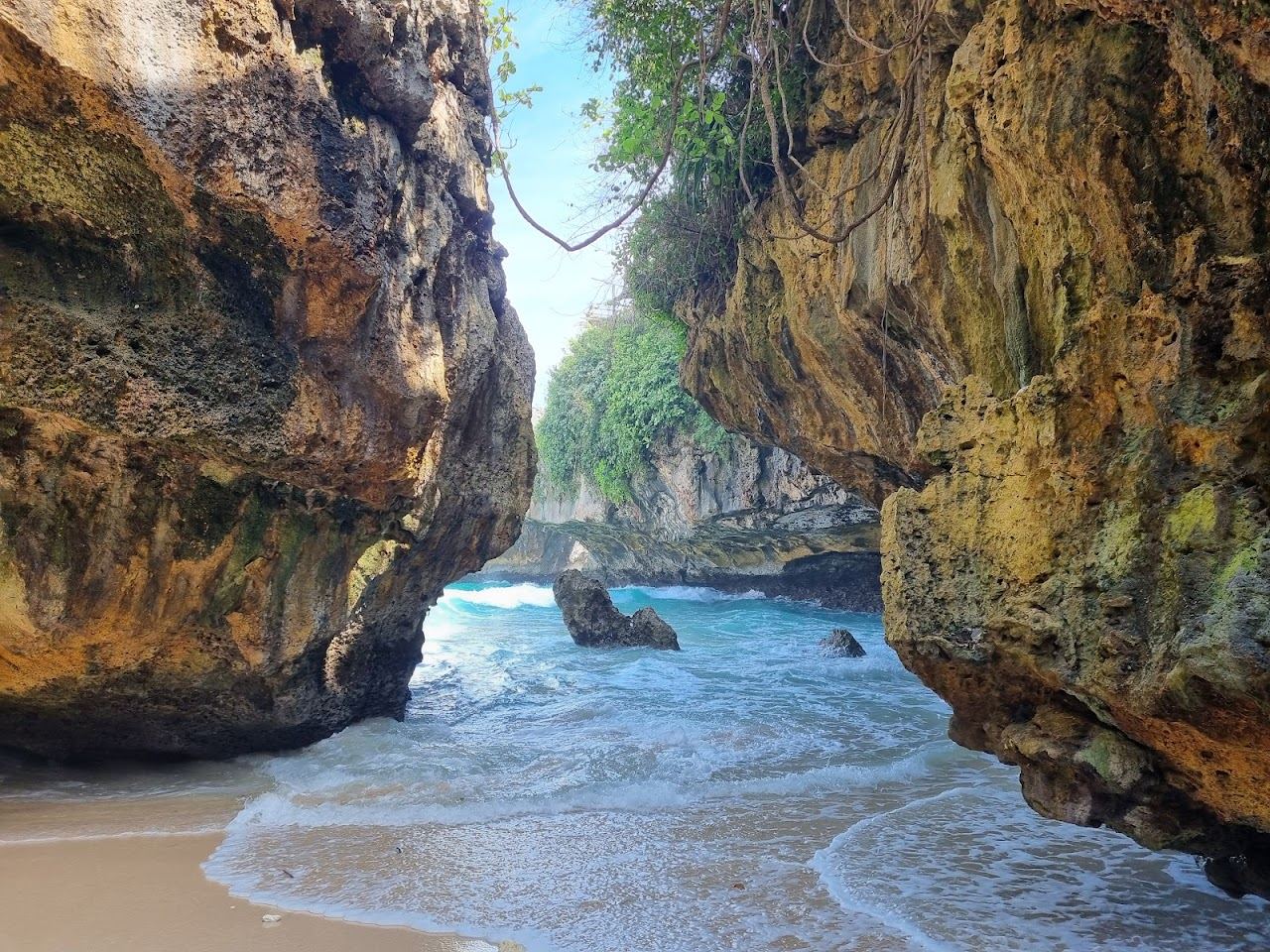 The cliff, cave entry and reef wave at Suluban Beach below Uluwatu in Bali