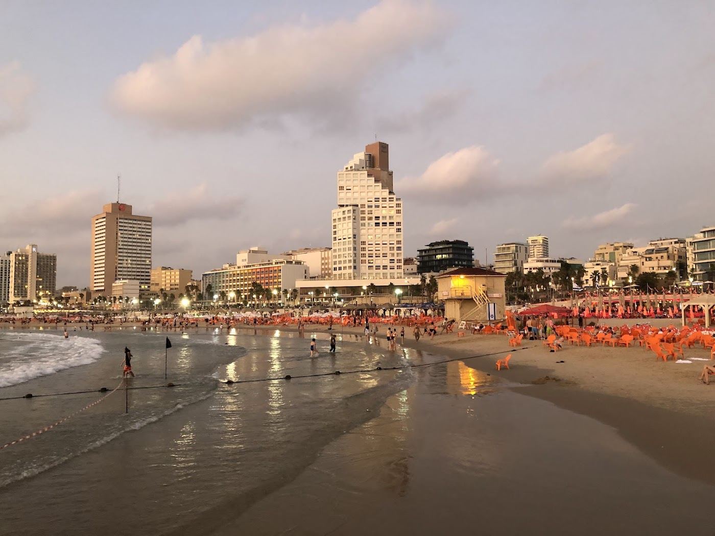 Rented sunbeds and umbrellas on a public beach along the Tel Aviv promenade
