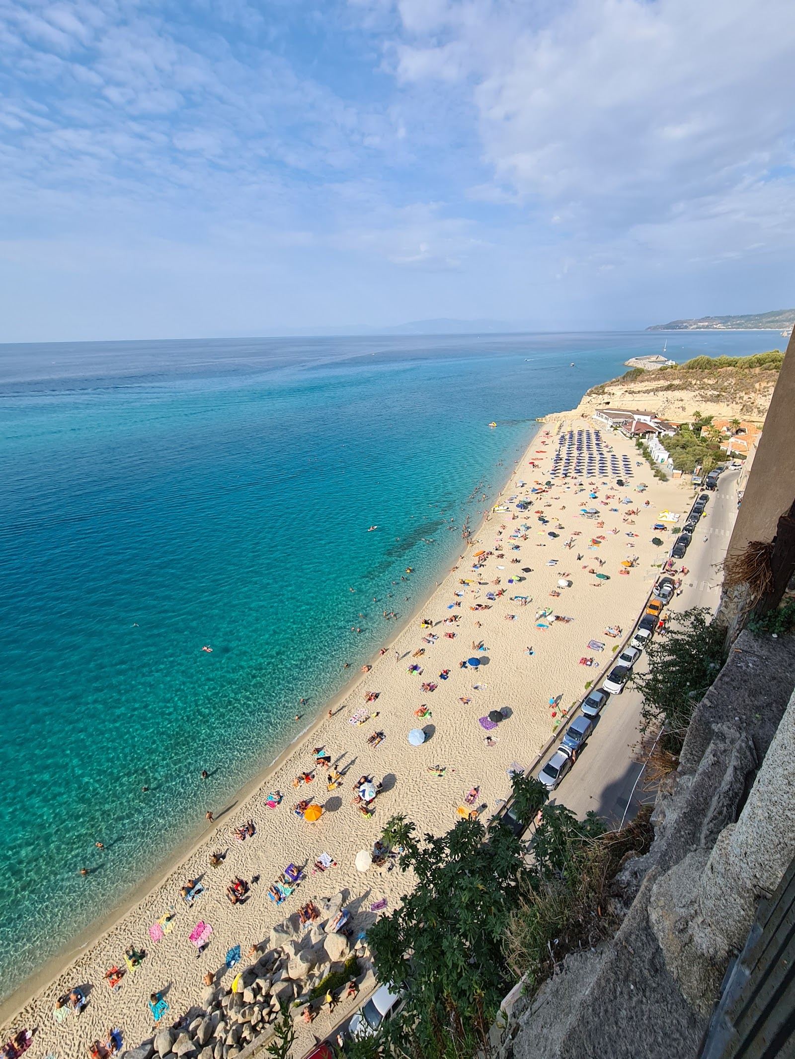 White sand and clear water below the cliff top old town of Tropea in Calabria