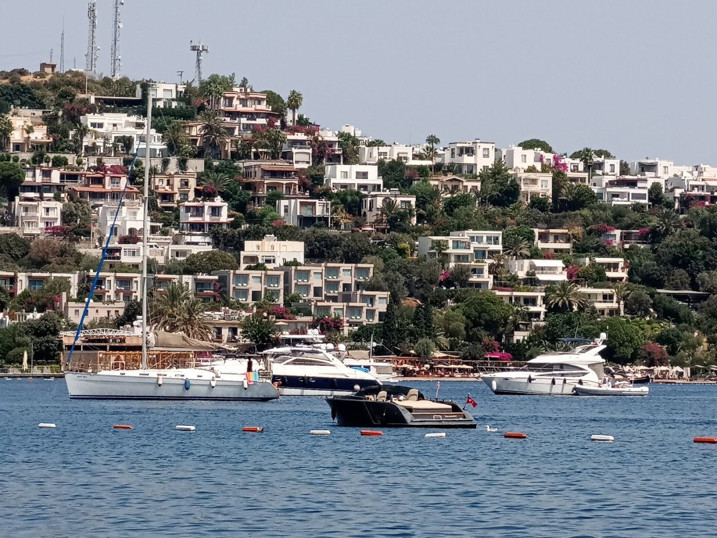 Turkbuku bay on the north coast of the Bodrum peninsula with beach club platforms and jetties over calm clear water in Turkey