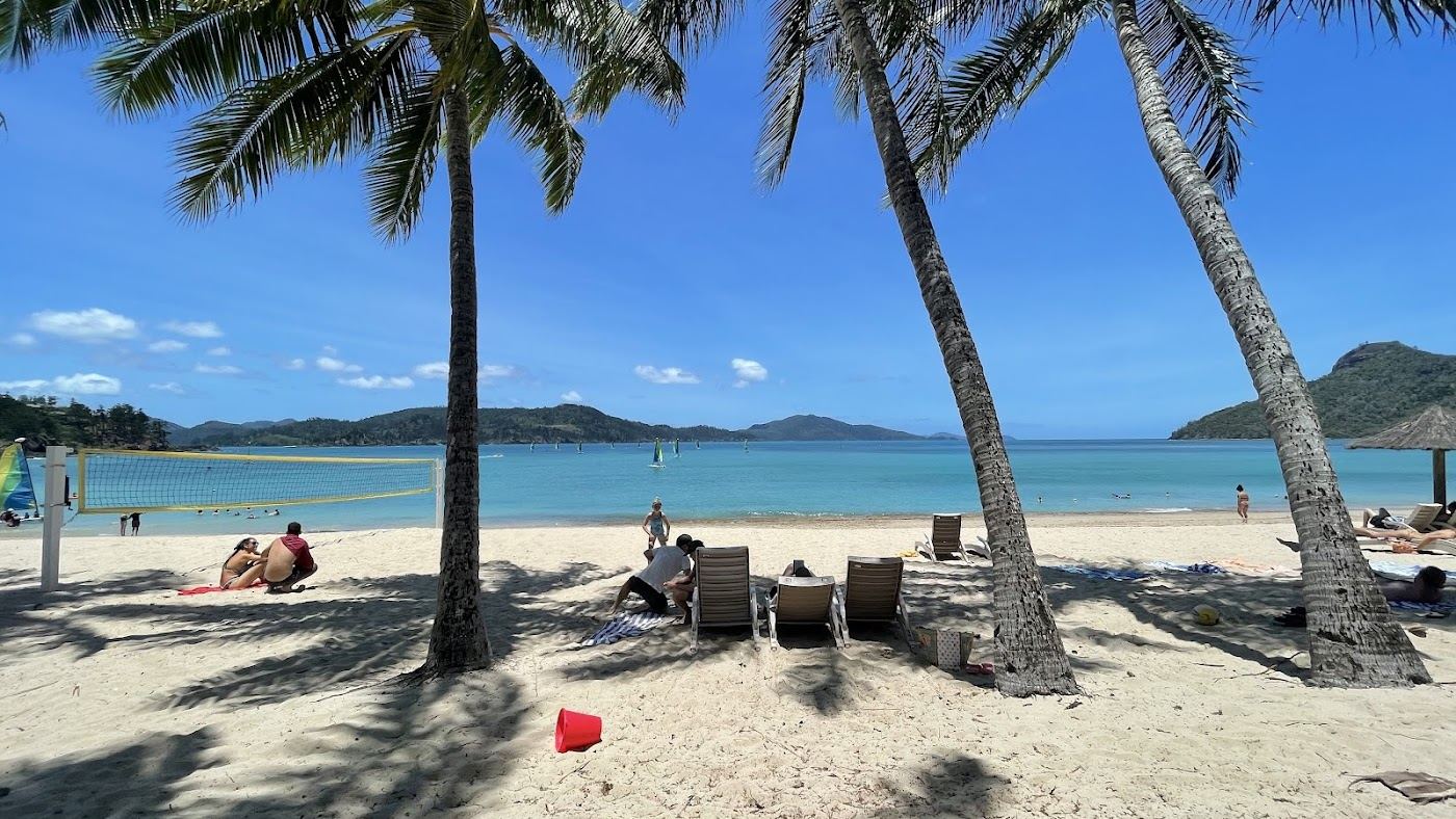 Calm resort beach and clear shallow water at Catseye Beach on Hamilton Island in the Whitsundays
