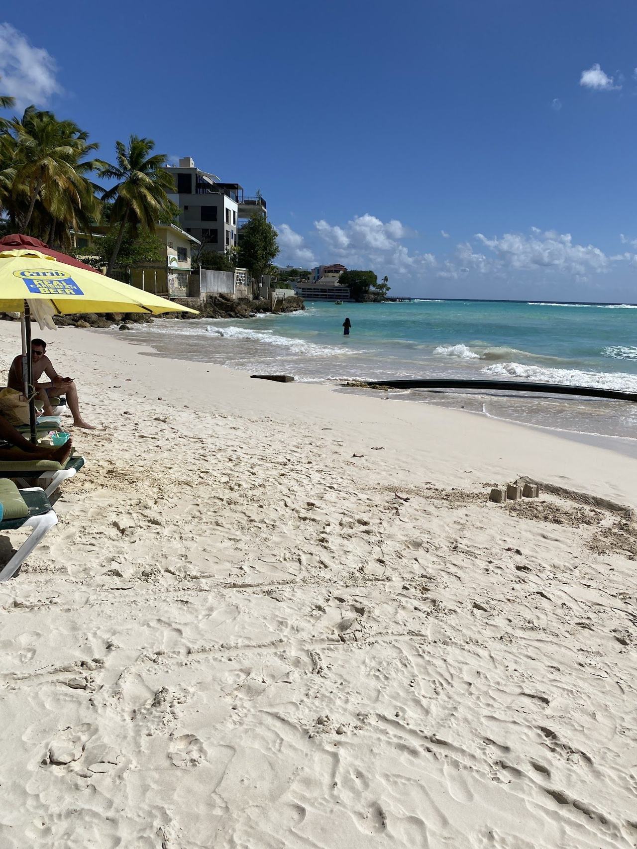 Calm shallow turquoise water and pale sand at Worthing Beach on the south coast of Barbados