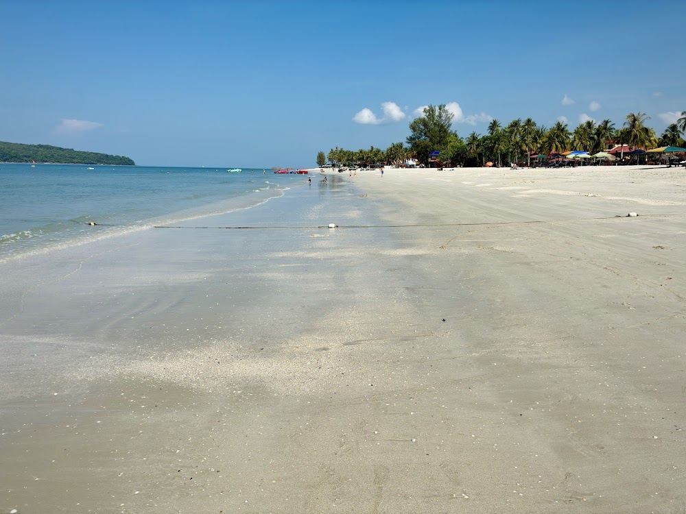 Long white sand and calm water at Pantai Cenang beach, Langkawi, near Yellow Beach Cafe